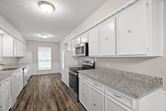 kitchen with stainless steel appliances, a textured ceiling, sink, dark hardwood / wood-style floors, and white cabinetry