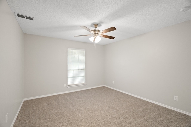 spare room with a textured ceiling, carpet flooring, and ceiling fan