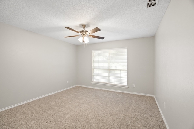 carpeted empty room featuring ceiling fan and a textured ceiling