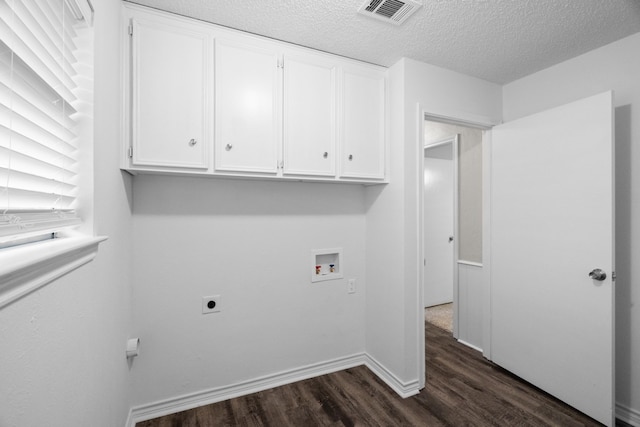 washroom featuring dark hardwood / wood-style flooring, electric dryer hookup, cabinets, a textured ceiling, and washer hookup