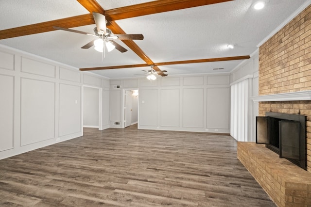 unfurnished living room with a fireplace, hardwood / wood-style flooring, and a textured ceiling