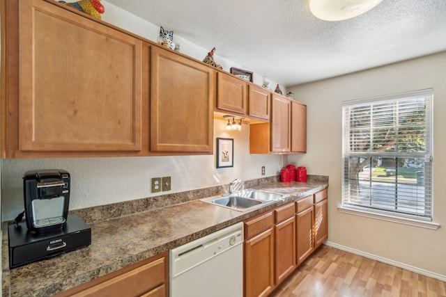 kitchen with sink, a textured ceiling, light hardwood / wood-style floors, and dishwasher