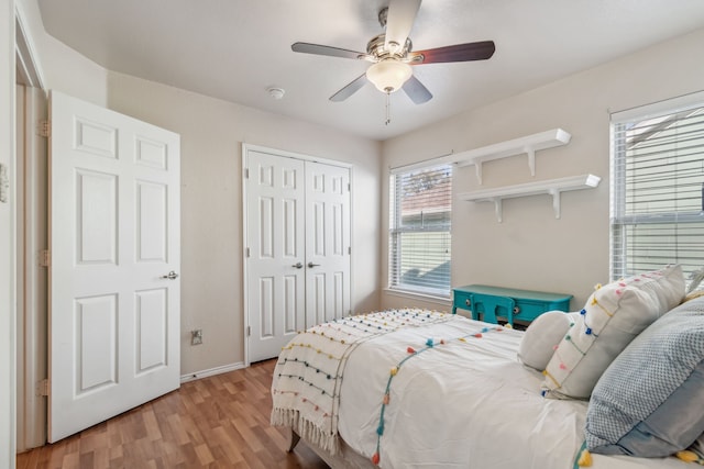 bedroom featuring ceiling fan, a closet, and light wood-type flooring