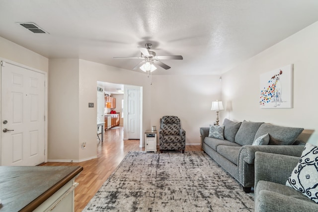 living room featuring ceiling fan and light hardwood / wood-style flooring