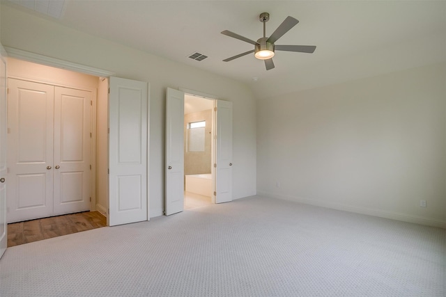 unfurnished bedroom with baseboards, visible vents, carpet floors, ceiling fan, and connected bathroom