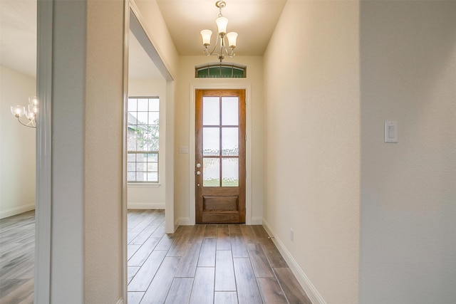 doorway to outside featuring a notable chandelier and light hardwood / wood-style flooring