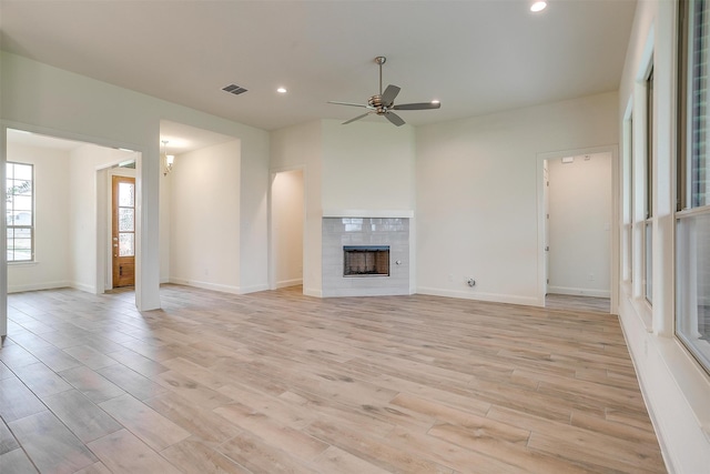 unfurnished living room with a fireplace, ceiling fan, and light hardwood / wood-style flooring