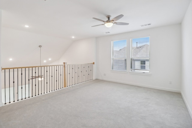 empty room featuring light carpet, ceiling fan, and vaulted ceiling