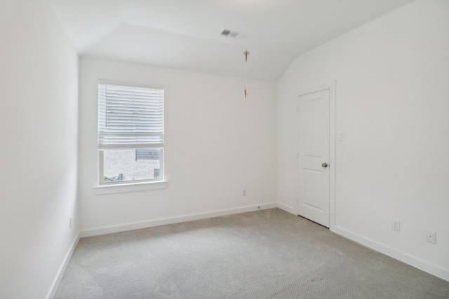 empty room with lofted ceiling and light colored carpet