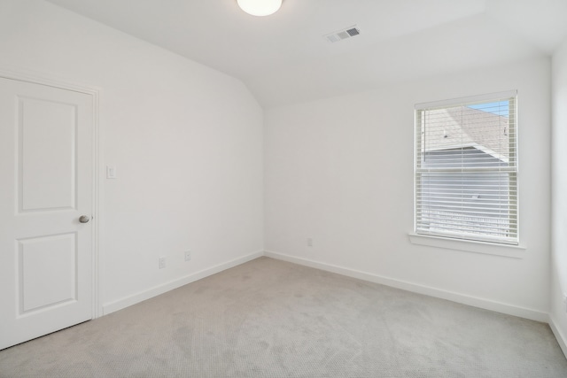 unfurnished room featuring light colored carpet and lofted ceiling