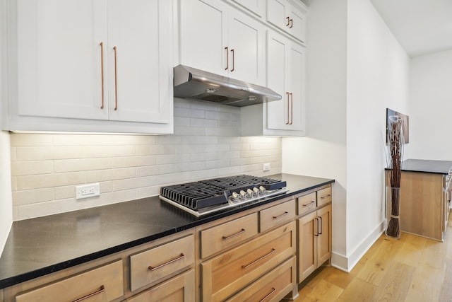 kitchen with white cabinets, light hardwood / wood-style flooring, stainless steel gas stovetop, and light brown cabinetry