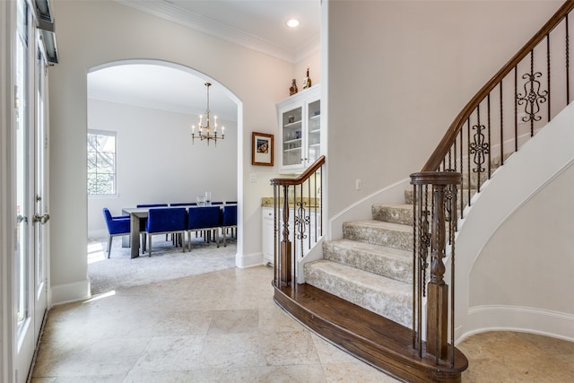 stairway with an inviting chandelier and crown molding