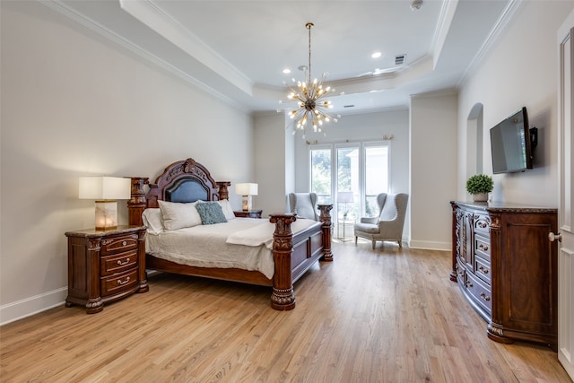 bedroom with light wood-type flooring, crown molding, and a tray ceiling