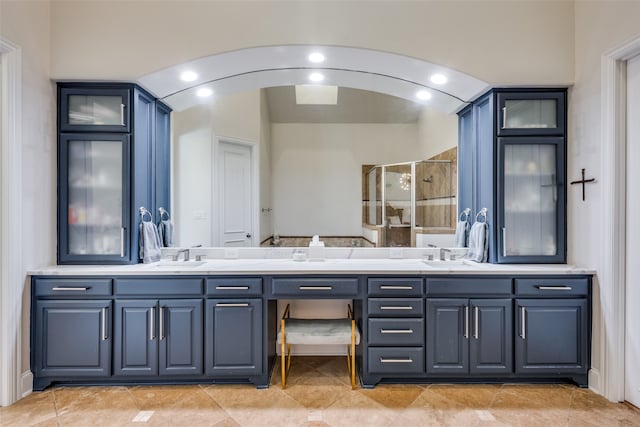 bathroom featuring tile patterned flooring, vanity, and a shower with shower door