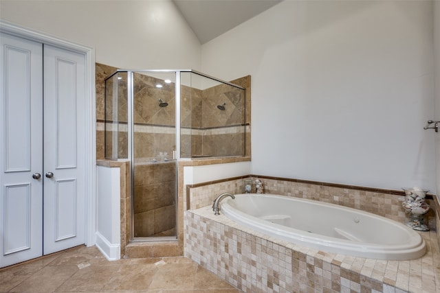 bathroom featuring independent shower and bath, vaulted ceiling, and tile patterned flooring