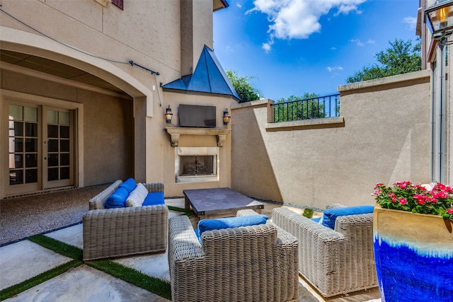 view of patio with an outdoor living space with a fireplace