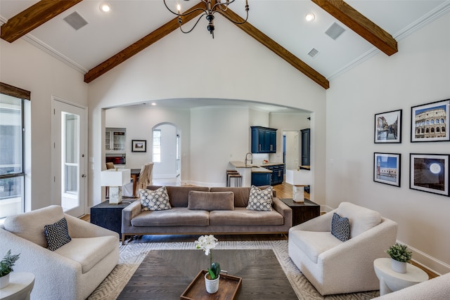 living room featuring beamed ceiling, crown molding, sink, and high vaulted ceiling