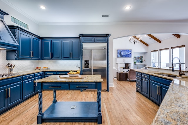 kitchen featuring sink, blue cabinetry, backsplash, light wood-type flooring, and appliances with stainless steel finishes