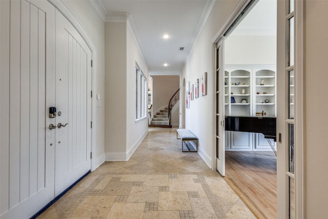 foyer entrance featuring light hardwood / wood-style floors and ornamental molding