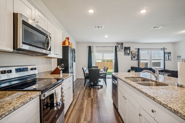 kitchen featuring dark hardwood / wood-style flooring, white cabinets, sink, and stainless steel appliances