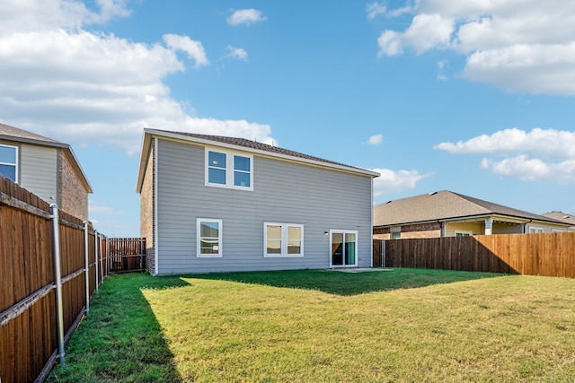 rear view of property featuring a lawn