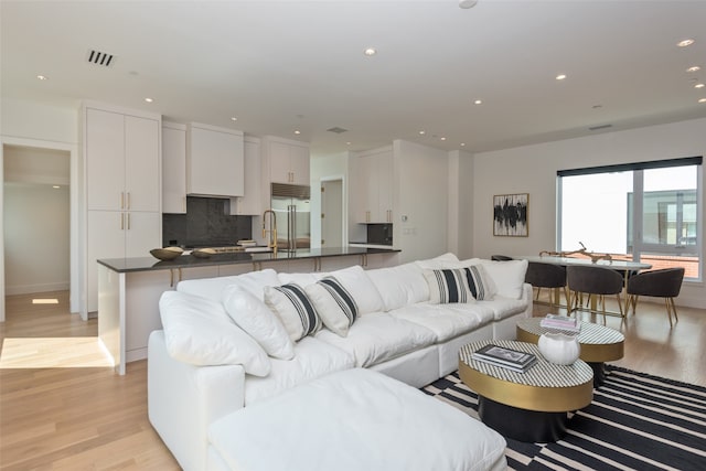 living room with sink and light hardwood / wood-style flooring