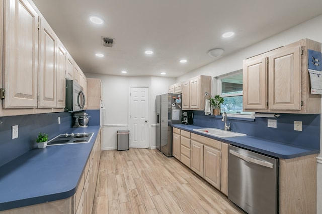 kitchen featuring light brown cabinetry, appliances with stainless steel finishes, sink, and light hardwood / wood-style floors