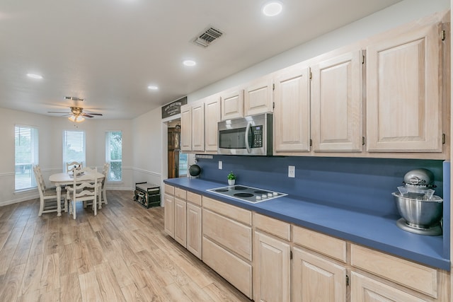 kitchen with light brown cabinetry, white electric cooktop, ceiling fan, and light wood-type flooring