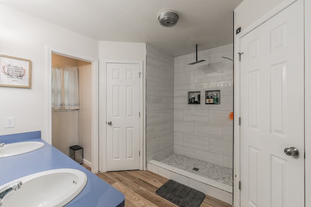 bathroom featuring vanity, wood-type flooring, and tiled shower