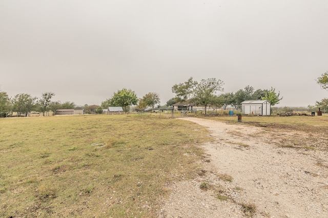 view of yard with a rural view and a storage unit