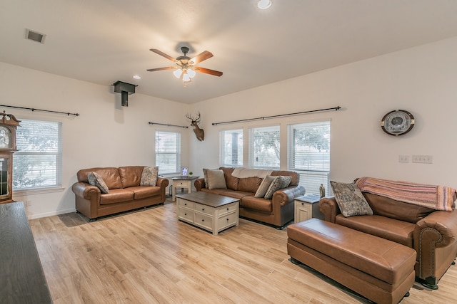 living room featuring light hardwood / wood-style floors, ceiling fan, and a healthy amount of sunlight