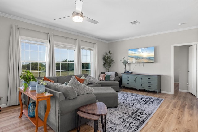 living room featuring ceiling fan, ornamental molding, and light hardwood / wood-style flooring