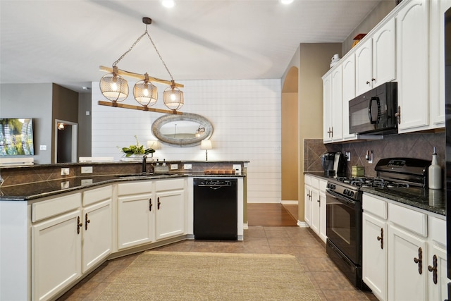 kitchen featuring white cabinetry, sink, black appliances, dark stone countertops, and pendant lighting