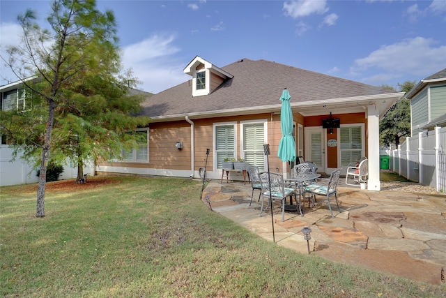 back of property featuring a patio and a yard