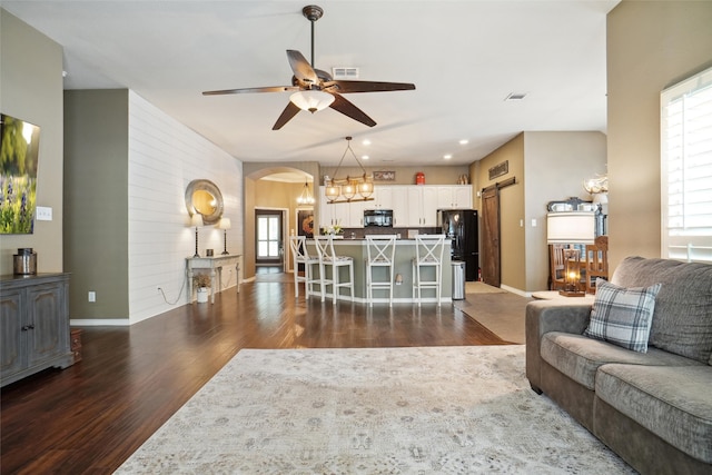 living room with dark hardwood / wood-style flooring and ceiling fan