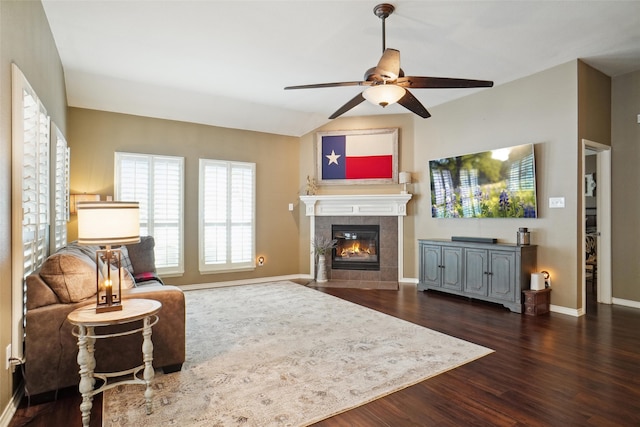 living room featuring dark wood-type flooring, a tile fireplace, and ceiling fan