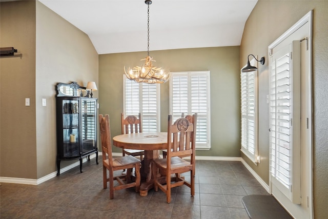 dining space with dark tile patterned flooring, plenty of natural light, and vaulted ceiling