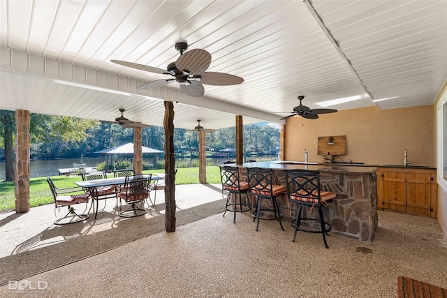 view of patio with an outdoor wet bar and a water view