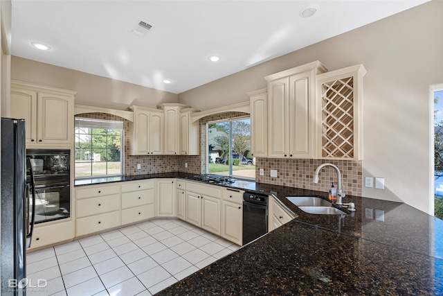 kitchen featuring black appliances, tasteful backsplash, sink, and a healthy amount of sunlight