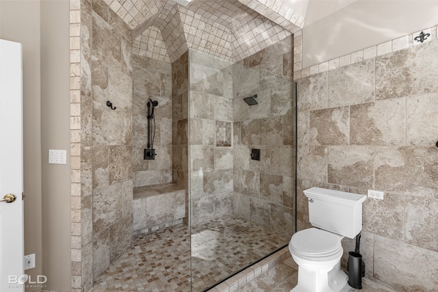 bathroom featuring a tile shower and toilet