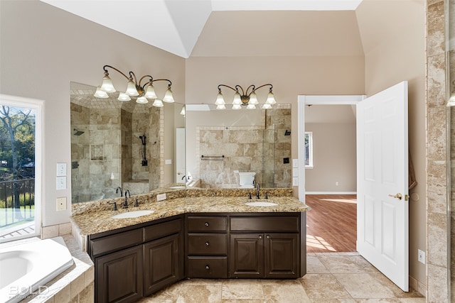 bathroom featuring vanity, hardwood / wood-style floors, shower with separate bathtub, and vaulted ceiling