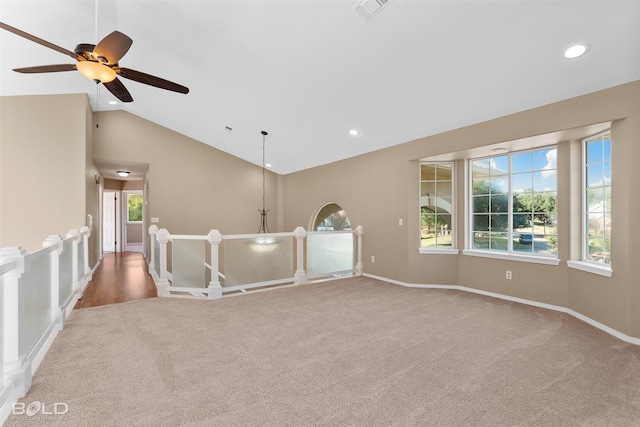 carpeted spare room featuring ceiling fan and lofted ceiling