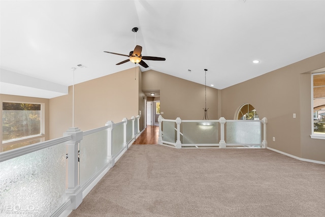 spare room featuring ceiling fan, light colored carpet, and lofted ceiling