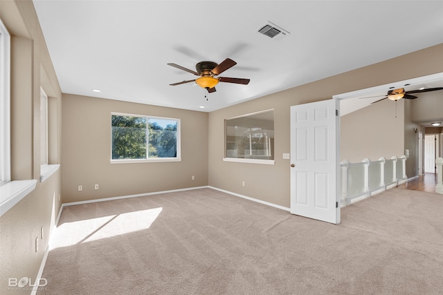 carpeted spare room with ceiling fan