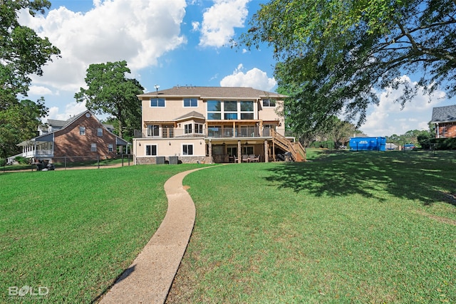 back of property with a wooden deck and a yard