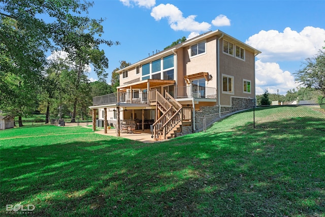 rear view of house with a yard, a patio, and a wooden deck