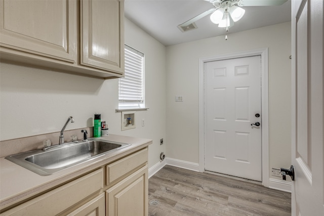 laundry area with cabinets, sink, washer hookup, hookup for an electric dryer, and light hardwood / wood-style flooring