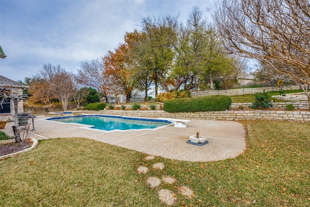 view of pool featuring a diving board, a lawn, and a patio