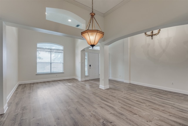 unfurnished living room featuring hardwood / wood-style floors and ornamental molding