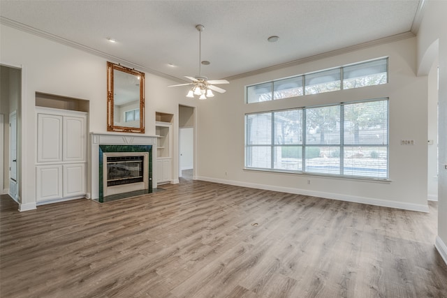 unfurnished living room with light hardwood / wood-style flooring, a textured ceiling, crown molding, and ceiling fan